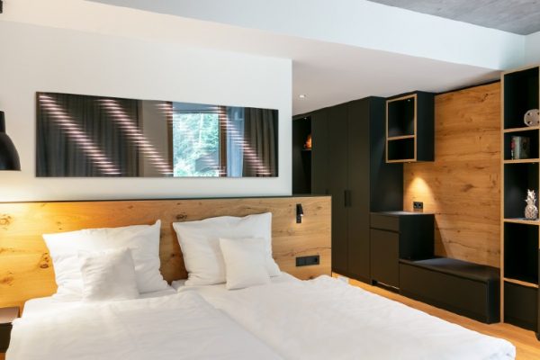Ein Hotelzimmer mit einem beleuchteten Spiegel über dem Kopfteil des Bettes hängen