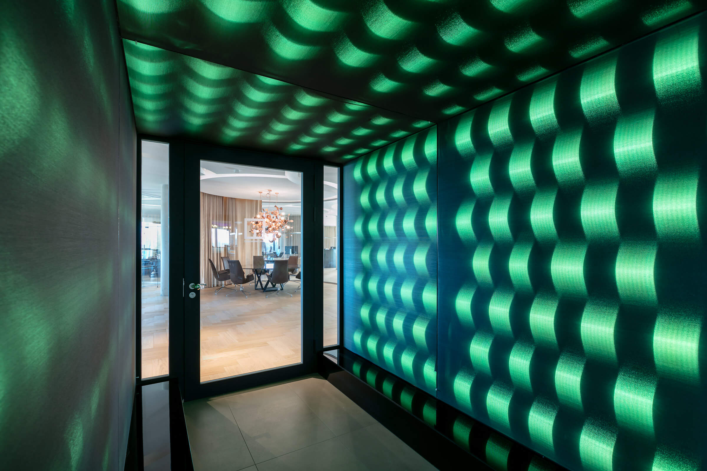 Seitlicher Anblick eines Eingangskorridors mit grün leuchtenden LED Leuchrahmen